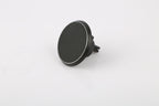 A black circular car dashboard mount with a magnetic surface and a small protruding clip, shown on a plain white background.