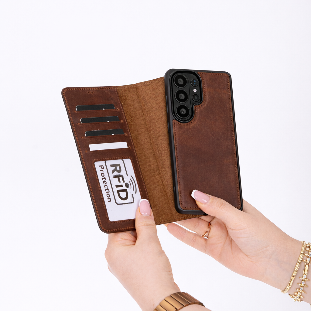 Brown leather phone case with RFID protection feature held by a hand on a white background