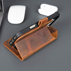 Brown leather phone case with a phone inside on a gray surface