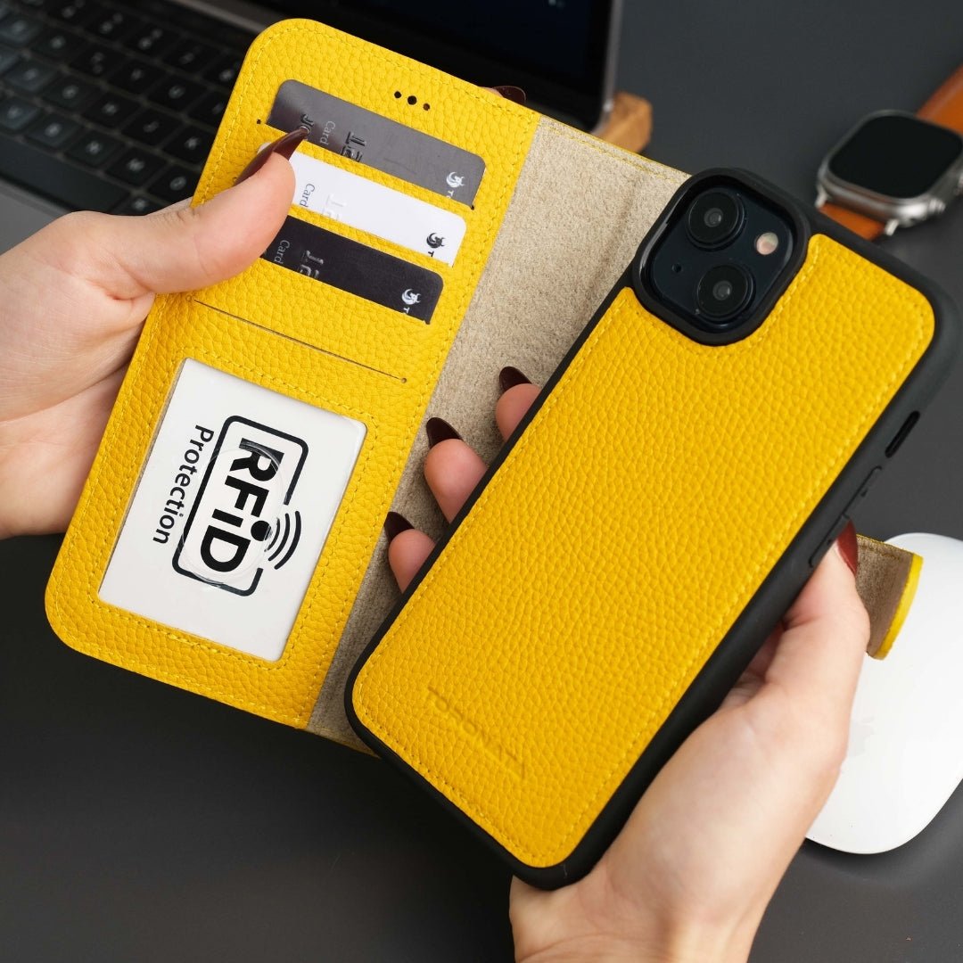 Yellow phone case with RFID protection feature held by a hand, with a blurred background.